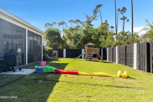 view of yard with a sunroom and a playground