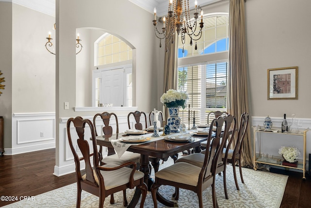 dining space with a healthy amount of sunlight, ornamental molding, and dark hardwood / wood-style flooring