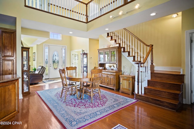 dining area with a high ceiling and dark hardwood / wood-style flooring