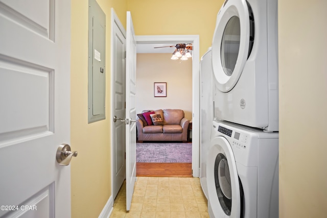 clothes washing area with ceiling fan, light wood-type flooring, stacked washer / dryer, and electric panel