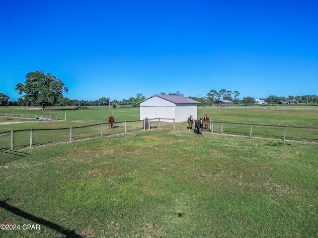 view of yard with a rural view and an outdoor structure