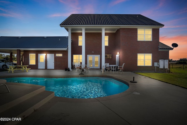 pool at dusk featuring a patio area