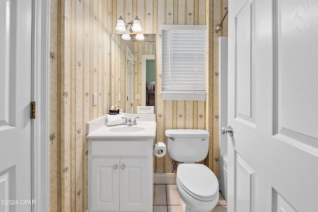 bathroom featuring vanity, toilet, tile patterned floors, and wooden walls