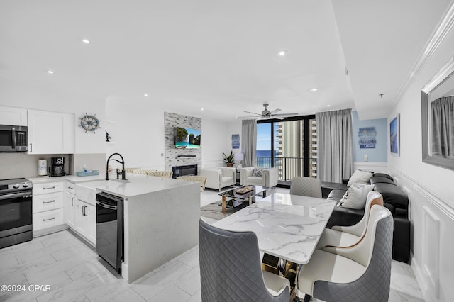 kitchen with white cabinetry, appliances with stainless steel finishes, light stone counters, and a kitchen breakfast bar