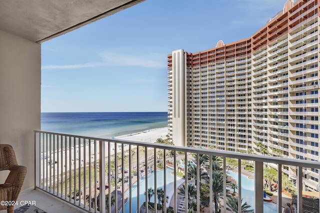 balcony featuring a view of the beach and a water view