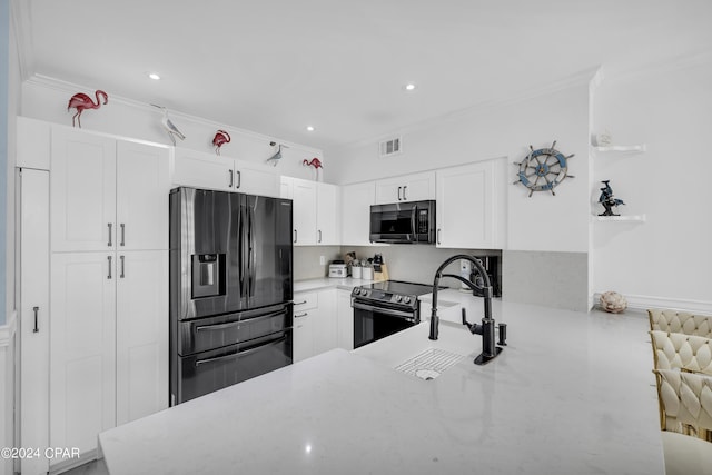 kitchen with stainless steel appliances, crown molding, white cabinets, and kitchen peninsula