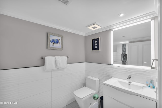 bathroom featuring vanity, ornamental molding, tile walls, and toilet