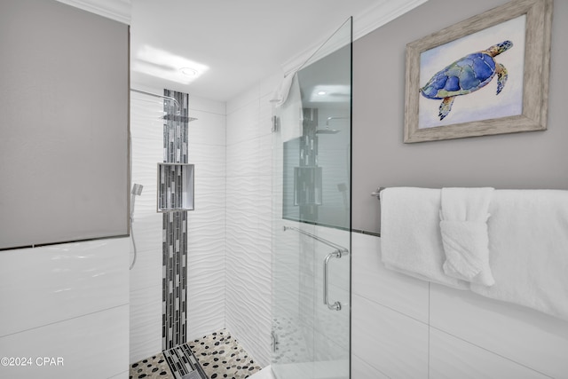 bathroom with a shower with door and ornamental molding