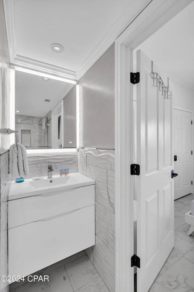 bathroom featuring ornamental molding, vanity, and tile walls