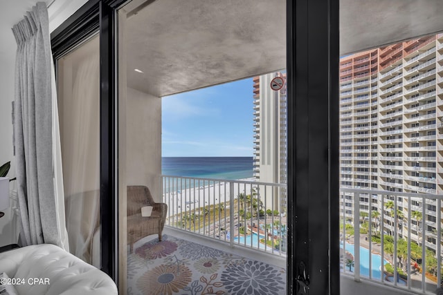 balcony featuring a beach view and a water view