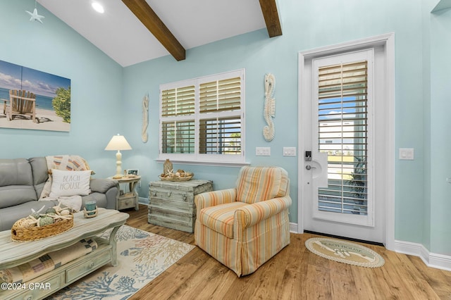 sitting room with hardwood / wood-style floors and vaulted ceiling with beams