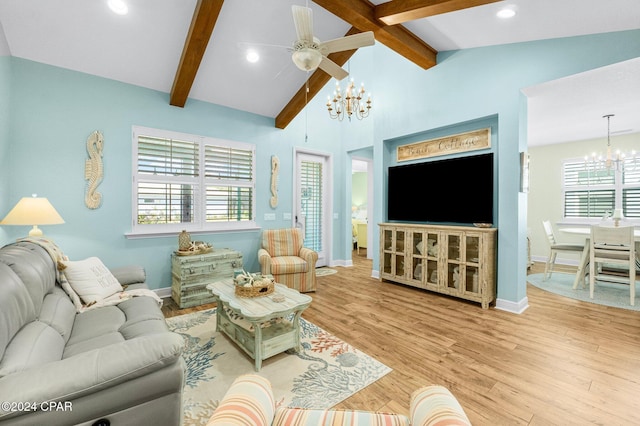 living room featuring a wealth of natural light, light hardwood / wood-style flooring, vaulted ceiling with beams, and ceiling fan with notable chandelier