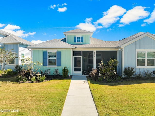 view of front of house featuring a front lawn and a sunroom