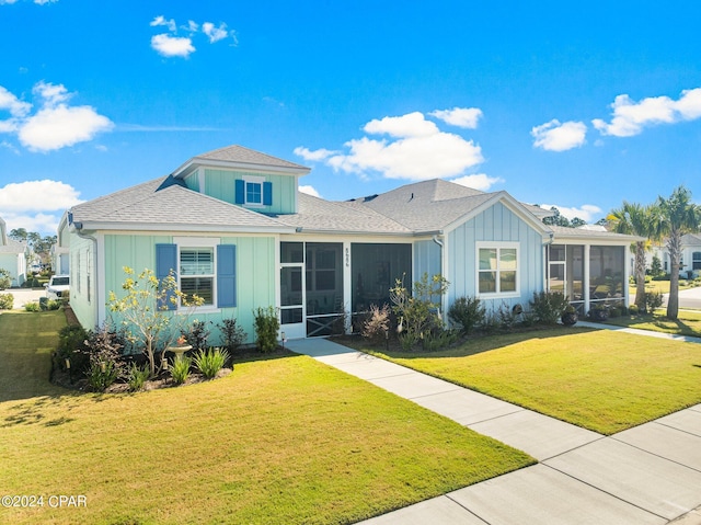 view of front of home with a front yard and a sunroom