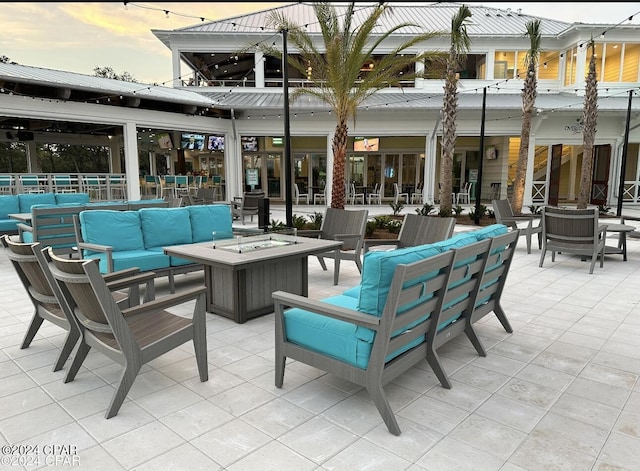 patio terrace at dusk with an outdoor living space with a fire pit