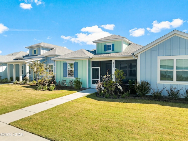 view of front of home featuring a sunroom and a front lawn