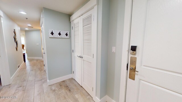 corridor with light hardwood / wood-style floors