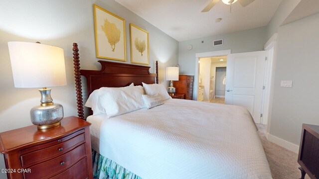 bedroom with ensuite bath, light colored carpet, and ceiling fan