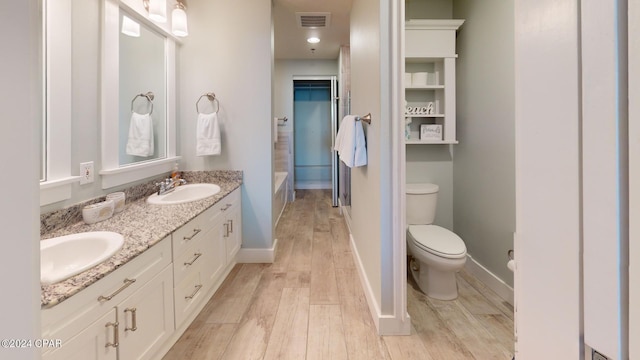 full bath featuring visible vents, toilet, wood finished floors, and a sink