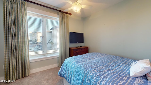 carpeted bedroom featuring baseboards and a ceiling fan