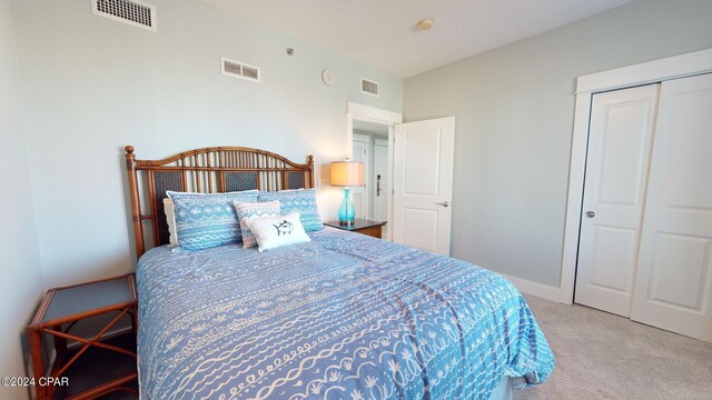 bedroom featuring light carpet and a closet