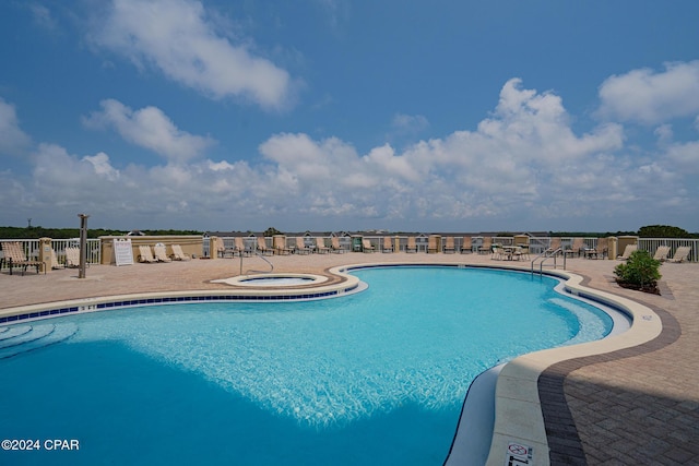 pool featuring a patio, a community hot tub, and fence