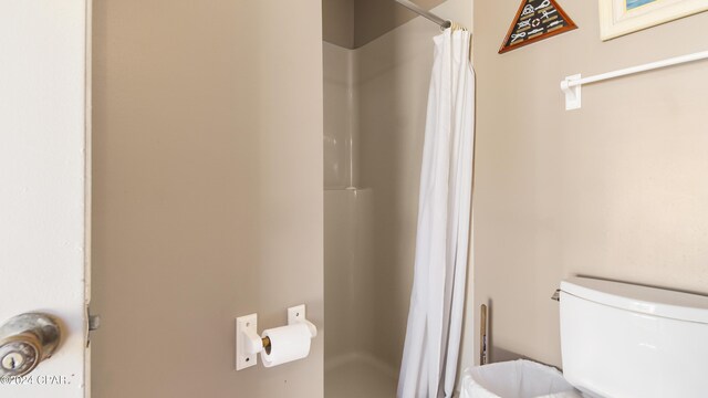 bathroom with a shower with curtain and toilet