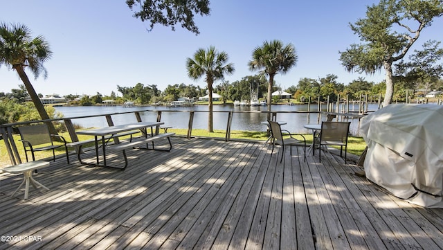 deck with a water view and area for grilling