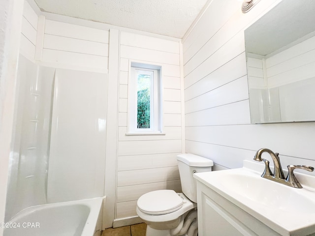 full bathroom featuring vanity, tile patterned floors, wooden walls, toilet, and a textured ceiling