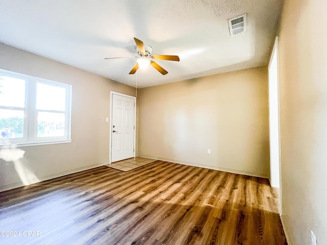 unfurnished room with ceiling fan and hardwood / wood-style flooring