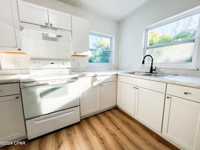 kitchen featuring white cabinets, a healthy amount of sunlight, stove, and sink