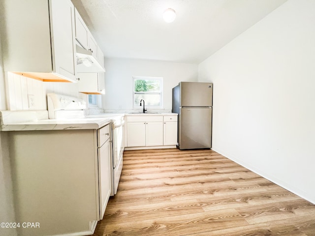 kitchen with sink, light hardwood / wood-style flooring, stainless steel fridge, white cabinetry, and range