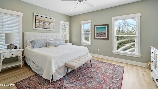 bedroom featuring multiple windows, ceiling fan, and light hardwood / wood-style floors