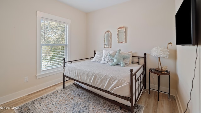 bedroom with hardwood / wood-style floors and multiple windows