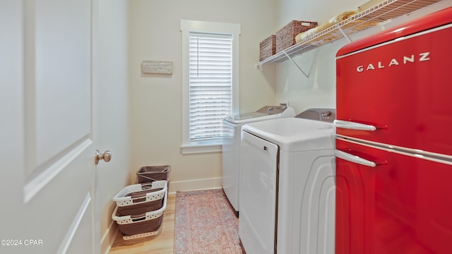 washroom featuring washing machine and clothes dryer and light hardwood / wood-style flooring