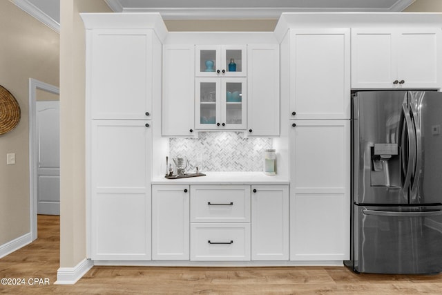 kitchen featuring white cabinets, glass insert cabinets, stainless steel refrigerator with ice dispenser, and light countertops