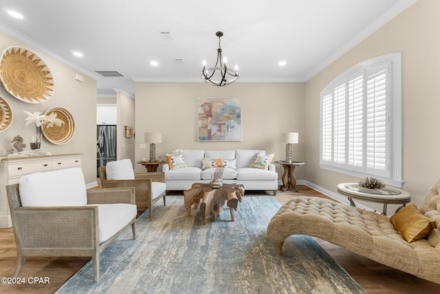 living area with visible vents, light wood-style flooring, ornamental molding, a chandelier, and baseboards