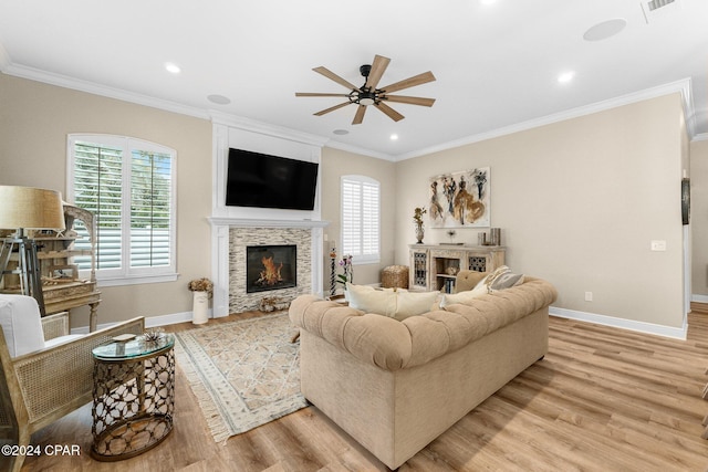 living room featuring baseboards, a glass covered fireplace, light wood-style flooring, and a healthy amount of sunlight