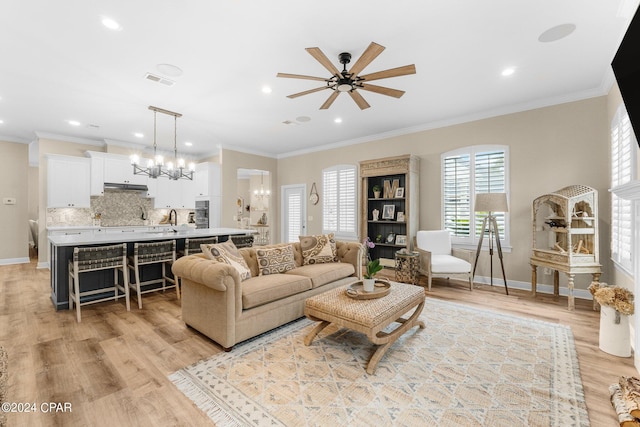 living area featuring light wood-style flooring, visible vents, and crown molding