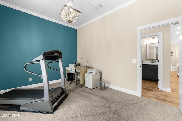 exercise room with visible vents, baseboards, ornamental molding, a chandelier, and a sink