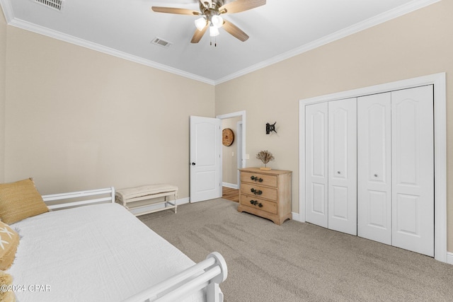 bedroom featuring carpet floors, visible vents, baseboards, a closet, and crown molding