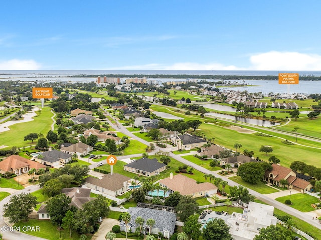 aerial view featuring a water view, view of golf course, and a residential view