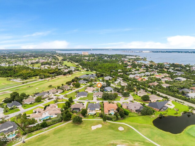 drone / aerial view featuring a water view, view of golf course, and a residential view