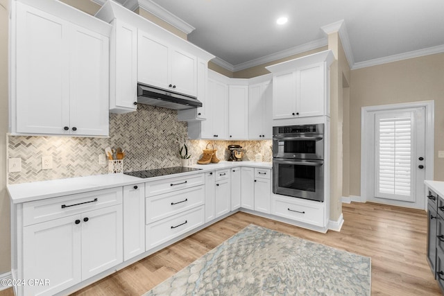 kitchen with stainless steel double oven, light countertops, under cabinet range hood, and white cabinetry