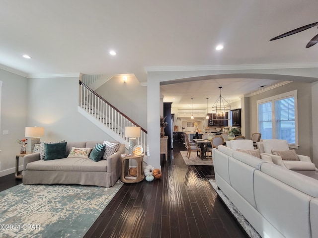 living room with crown molding, hardwood / wood-style floors, and ceiling fan with notable chandelier