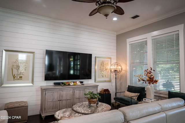 living room featuring crown molding, wooden walls, and ceiling fan