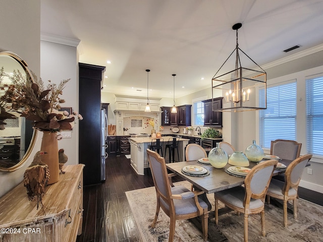 dining room featuring ornamental molding, a notable chandelier, dark hardwood / wood-style floors, and sink