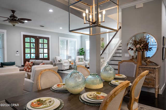 dining space featuring french doors, crown molding, wood-type flooring, and ceiling fan with notable chandelier