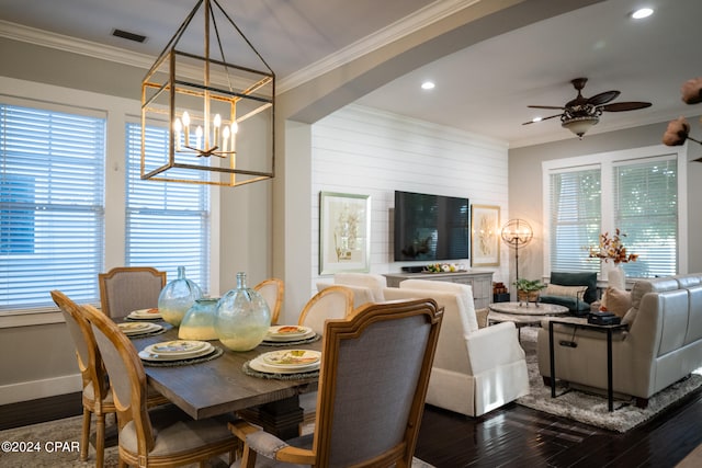 dining room featuring ornamental molding, dark wood-type flooring, ceiling fan with notable chandelier, and a wealth of natural light