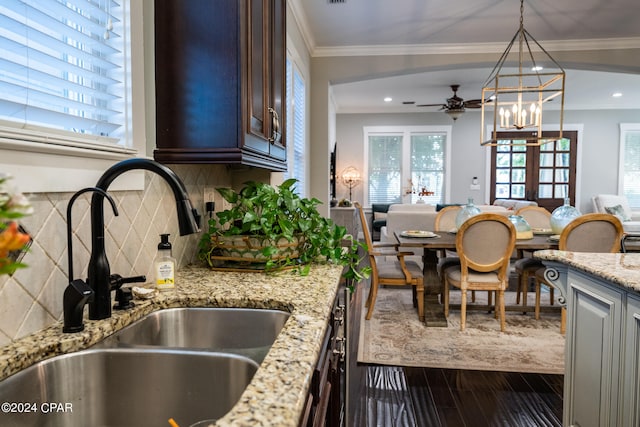 kitchen with tasteful backsplash, sink, dark brown cabinetry, hardwood / wood-style flooring, and ornamental molding